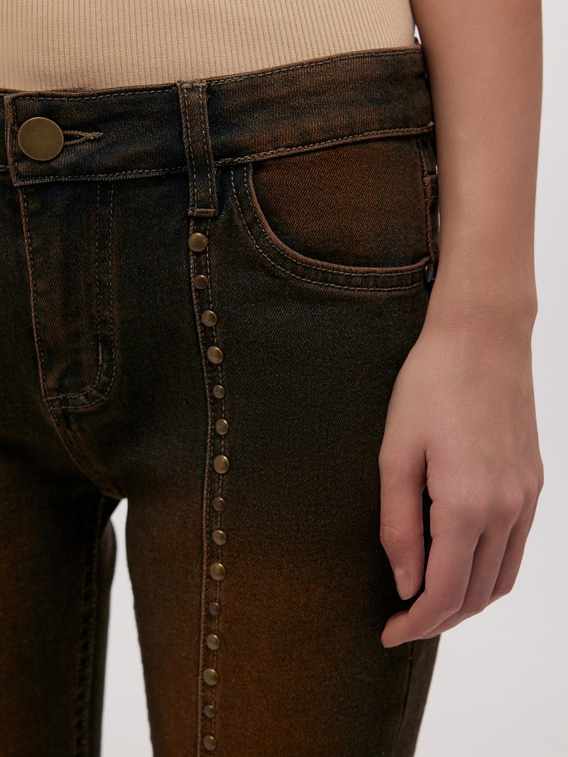 Расклешенные джинсы с клепками